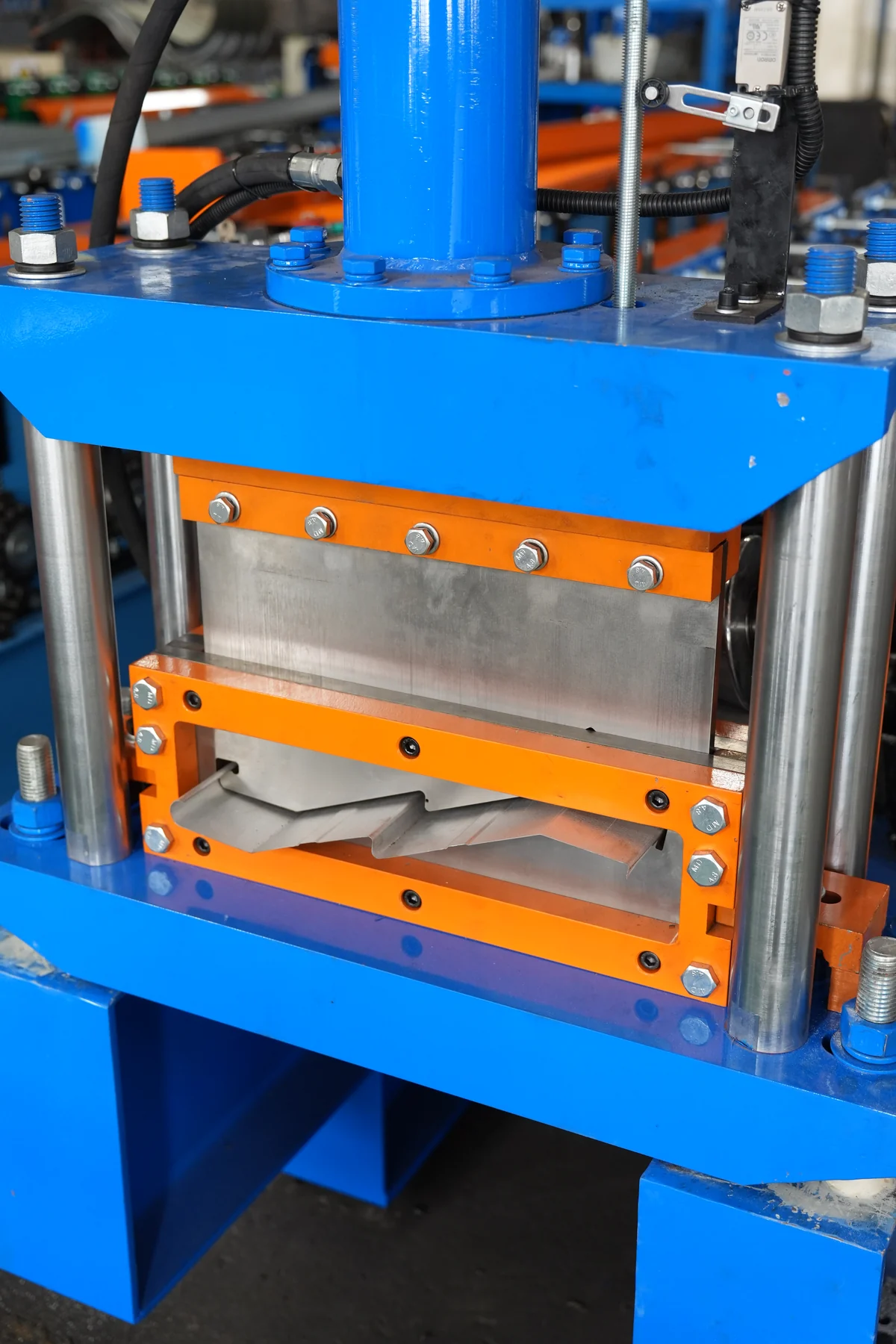 Hydraulic profile cut-off die with shaped blade opening on a roll forming line