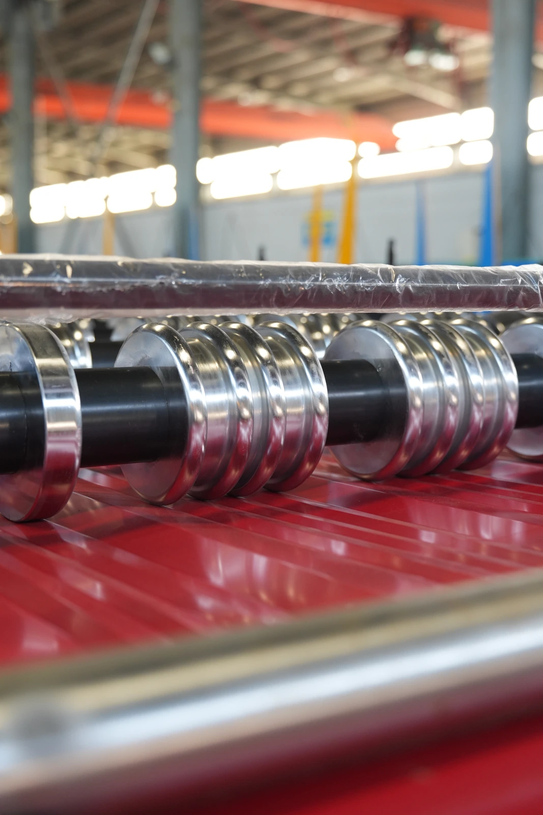 Roll forming rollers above a red sheet in our Xiamen production base