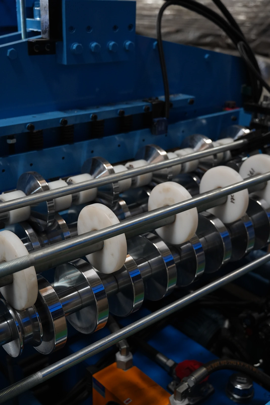 Rollers and white guide discs in a blue roll forming station in our Xiamen production base